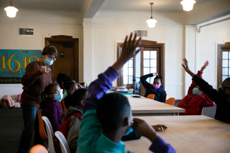 Students raise their hands during a discussion about poetry at the 1619 Freedom School