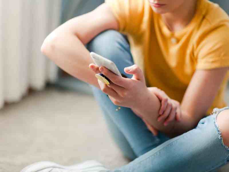 A teenager uses a cell phone to stay connected.