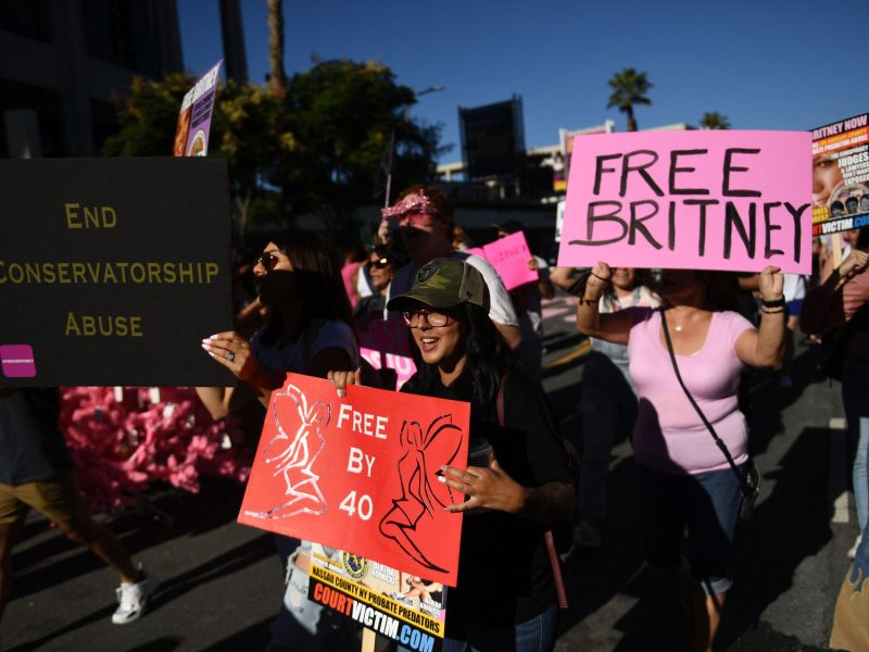 Britney Spears supporters hold up signs saying "Free Britney" and "End Conservatorship Abuse".