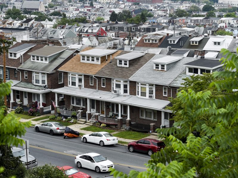 A sky-high view of a block of row homes. You can also see cars parked on the street.