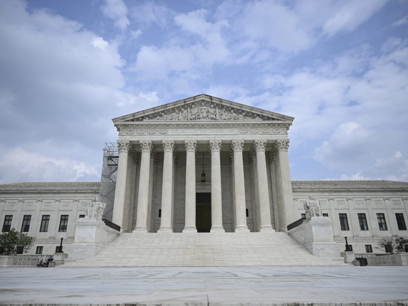 A look at the US Supreme Court. It has a white stone facade, numerous steps and several pillars.