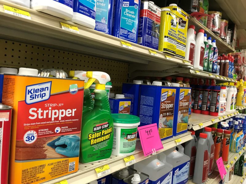 Paint strippers are displayed on a shelf in a hardware store.