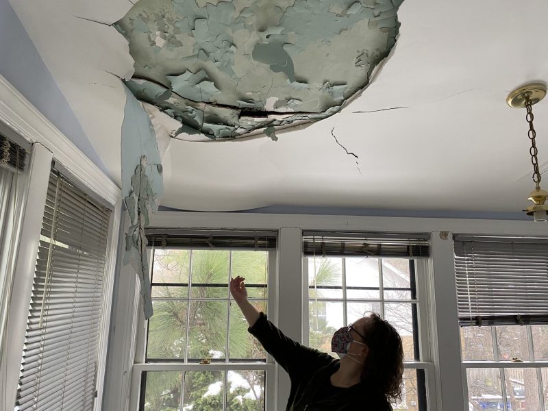 Sara Meacham gestures toward the cracks in the ceiling in her home in Washington, D.C.